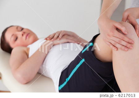 Masseuse massing the knee of a young woman 6217013