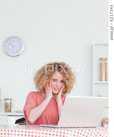 Pretty blonde female relaxing with her laptop while sitting in t 6217343