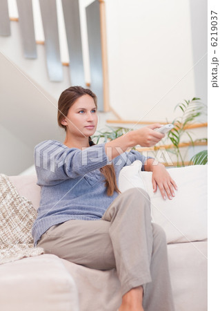 Portrait of a woman switching channel with a remote Portrait of a woman switching channel with a remote 6219037