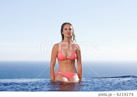 Woman sitting by a swimming pool 6219278