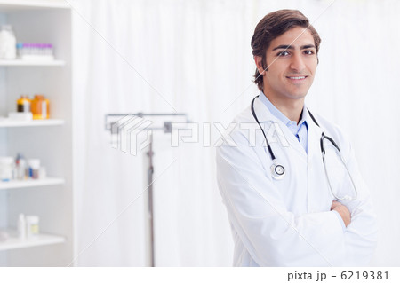 Smiling doctor standing in examination room 6219381