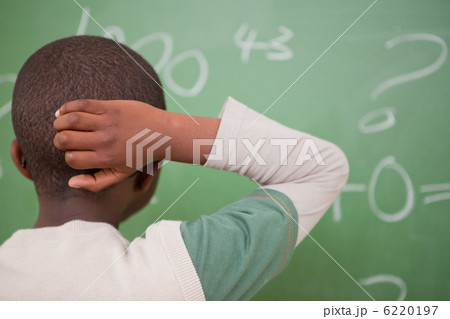 Schoolboy thinking with his hand on his head Schoolboy thinking with his hand on his head 6220197