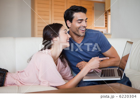 Laughing young couple using a laptop Laughing young couple using a laptop 6220304