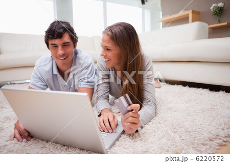 Couple lying on the floor shopping online 6220572