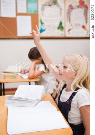 Portrait of a pupil raising her hand 6220573
