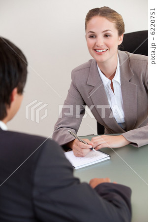 Portrait of a smiling manager interviewing a male applicant Portrait of a smiling manager interviewing a male applicant 6220751