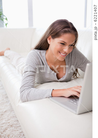 Woman on the sofa typing on her notebook 6221407