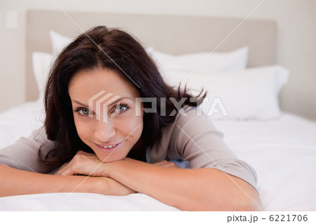 Smiling woman relaxing on the bed 6221706