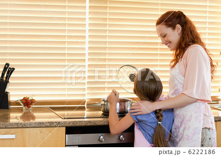 Cheerful mother showing her daughter how to cook 6222186