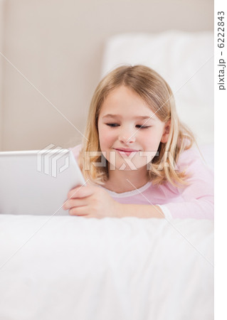 Portrait of a smiling little girl using a tablet computer Portrait of a smiling little girl using a tablet computer 6222843