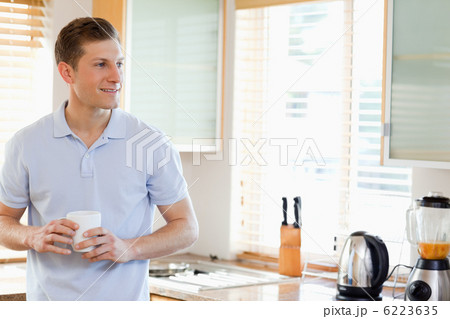 Man holding cup in the kitchen Man holding cup in the kitchen 6223635