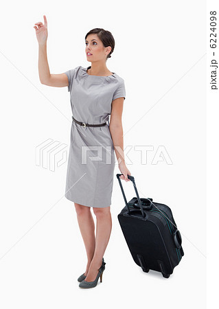 Woman with wheely bag calling a taxi 6224098