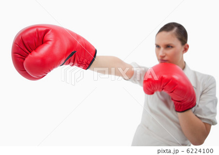 Businesswoman punching something with boxing gloves Businesswoman punching something with boxing gloves 6224100