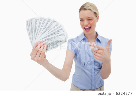 Woman holding money and pointing at it 6224277