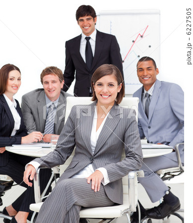 Assertive female executive sitting in front of her team Assertive female executive sitting in front of her team 6227505