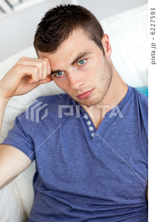 Bored young man sitting on the sofa 6227593