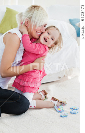 Cheerful little girl hugging her mother 6228475