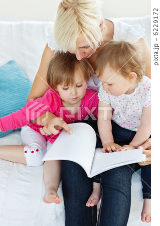 Glowing family reading a book on the sofa Glowing family reading a book on the sofa 6229172