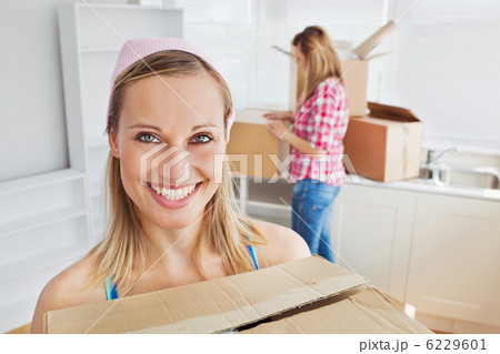 Two positive women carrying boxes at home 6229601