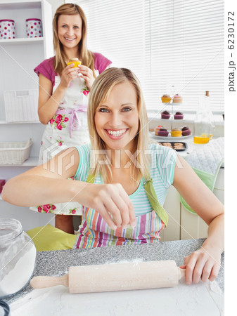 Animated female friends baking muffins smiling at the camera 6230172