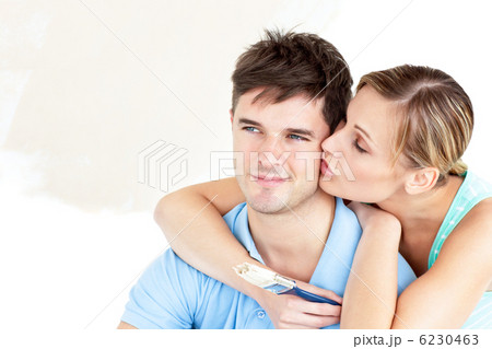 Hugging caucasian couple painting a room 6230463
