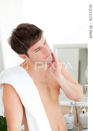 smiling man touching his face after shaving 6231016