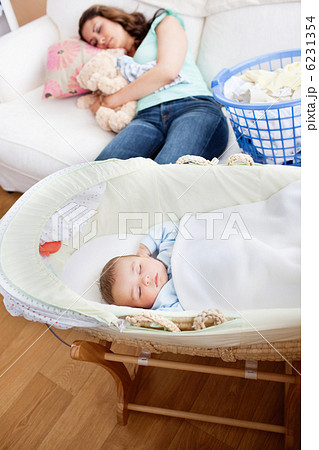 Young mother sleeping on the sofa while her baby is sleeping in Young mother sleeping on the sofa while her baby is sleeping in 6231354