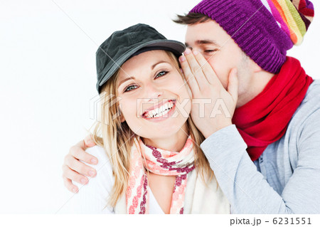young man with cap whispering something to his female friend 6231551