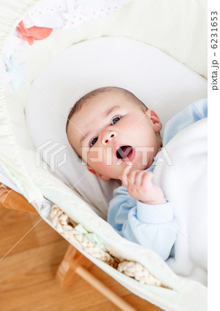 Portrait of a lively baby lying in his cradle 6231653