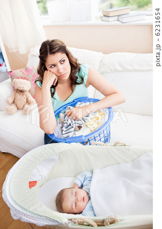 Bored mother waiting for her baby to wake-up sitting in the sofa 6231654