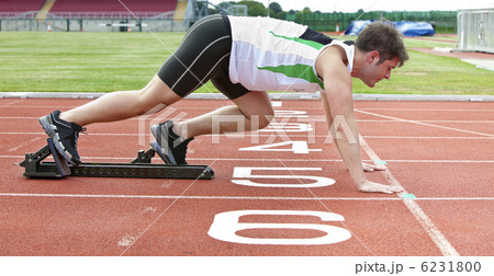Handsome sprinter on the starting line putting his foot in the s Handsome sprinter on the starting line putting his foot in the s 6231800