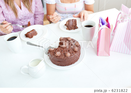 Close-up of caucasian female friends eating a chocolate cake in 6231822