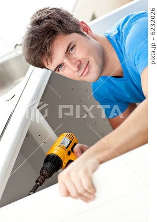 Charismatic man repairing his sink and holding a drill in the ki Charismatic man repairing his sink and holding a drill in the ki 6232026