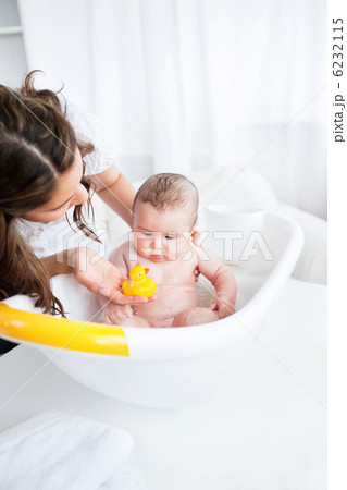 Beautiful mother giving the bath to her baby Beautiful mother giving the bath to her baby 6232115