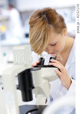 Serious female scientist using a microscope 6232150