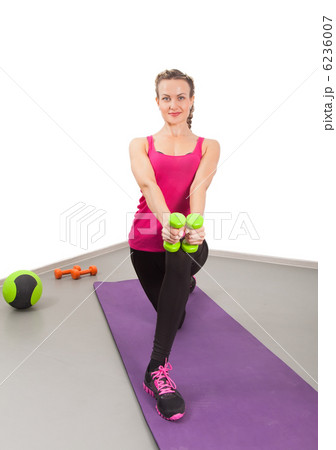 Athletic young woman training with dumbbells 6236007