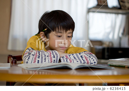 鉛筆を耳にはさんで勉強中の男の子 6236415