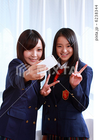 写メを撮る2人の女子高生の写真素材