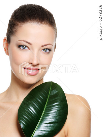 beautiful smiling woman with green leaf near her face 6273226