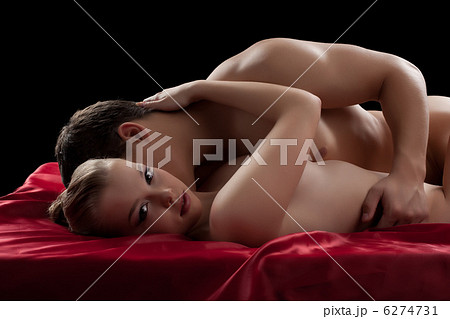 Young couple having sex on red sheet 6274731