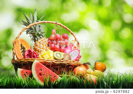 Basket of tropical fruits on green grass Basket of tropical fruits on green grass 6297882