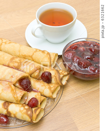 Pancakes with strawberry jam and a cup of tea. top view Pancakes with strawberry jam and a cup of tea. top view 6321662