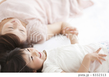 手をつないで寝転ぶ親子 6332313