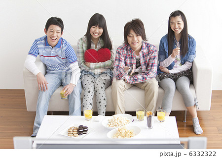 ソファーに座ってテレビを見ている男女中高生4人 6332322