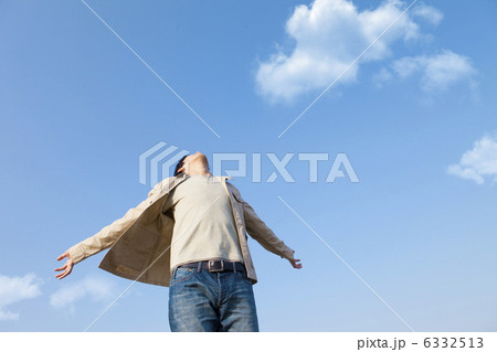 両手を広げて空を見上げる男性 6332513