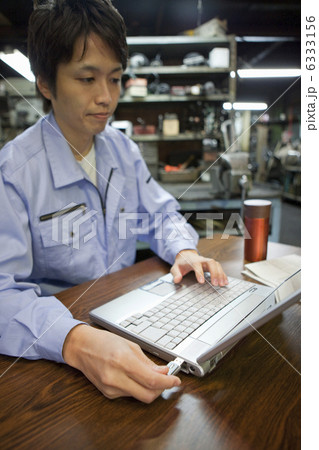 USBメモリを差し込む作業着姿の男性 USBメモリを差し込む作業着姿の男性 6333156