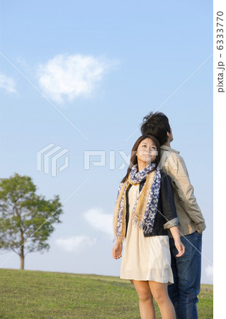 背中合わせになって空を見上げるカップル 背中合わせになって空を見上げるカップル 6333770