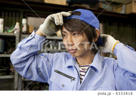 帽子を被る作業着姿の若者男性 6333818