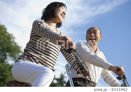 自転車に乗る笑顔の中高年夫婦 自転車に乗る笑顔の中高年夫婦 6333962