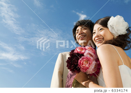 空を見上げる笑顔の新郎新婦 空を見上げる笑顔の新郎新婦 6334174